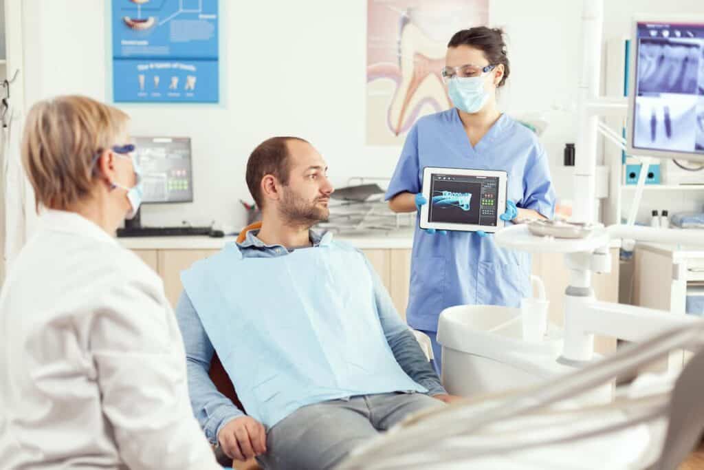 A person admiring their bright, white smile in a mirror after a successful teeth whitening treatment Coventry